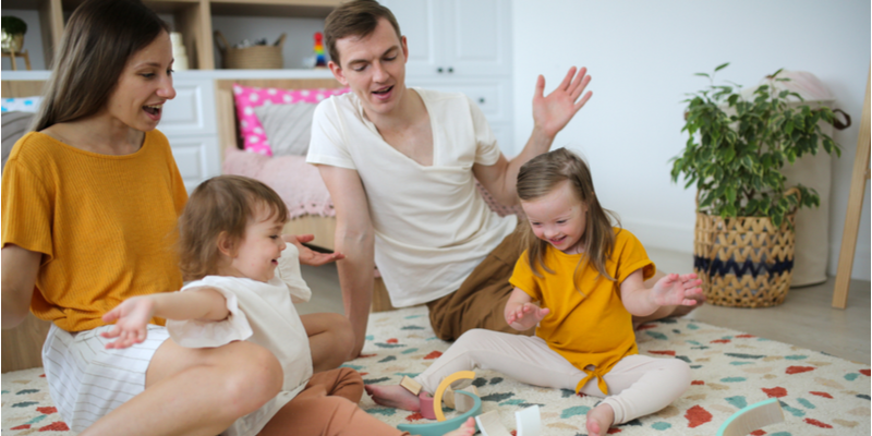 A beautiful Caucasian family with two children builds a wooden rainbow tower