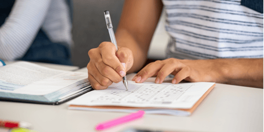 Close up of hands completeing a maths test