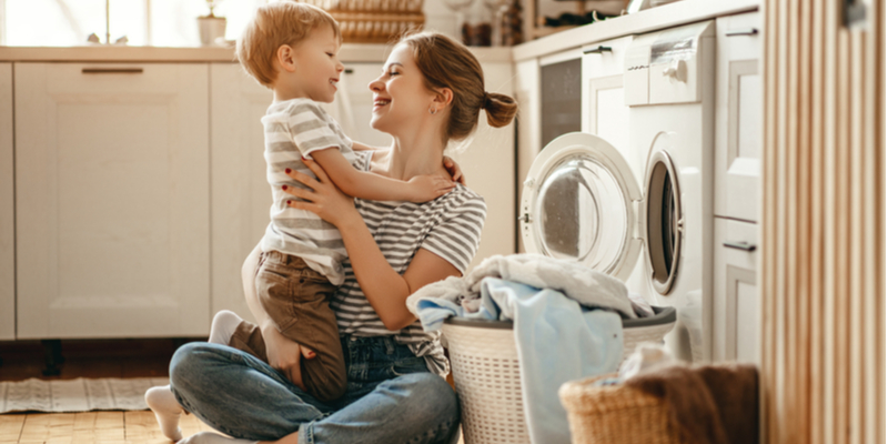 Happy family mother housewife and child son in laundry
