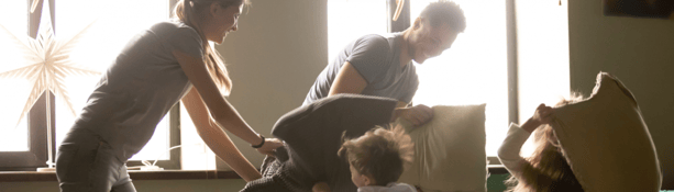 family having a pillow fight during lockdown