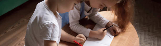 siblings drawing picture children drawing a picture on coffee table during lockdiwn