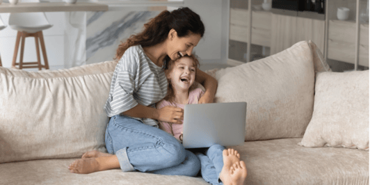 Lead by example Mum and duaghter on laptop, laughing on the couch
