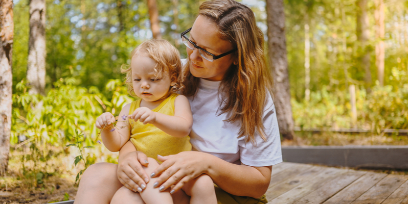 Mother and daughter playing spend time together outdoors at countryside front yard summertime.