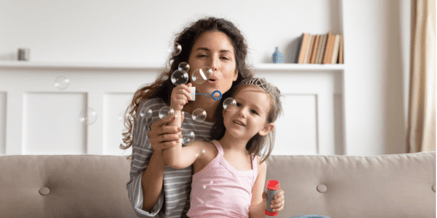 Mum and daughter blowing bubbles together