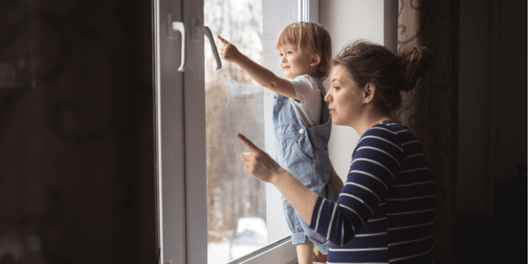 Mum and young son looking out of the window together