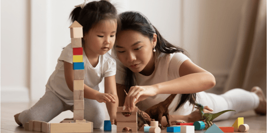 Mum and. daughter playing blocks together