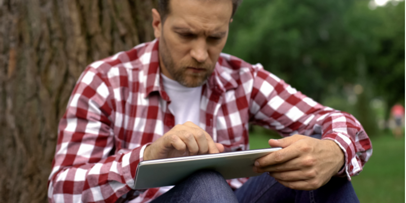 Next steps, Dad booking an  online counselling session for his son on a tablet