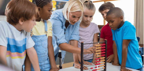 Teacher teaching children math on abacus.
