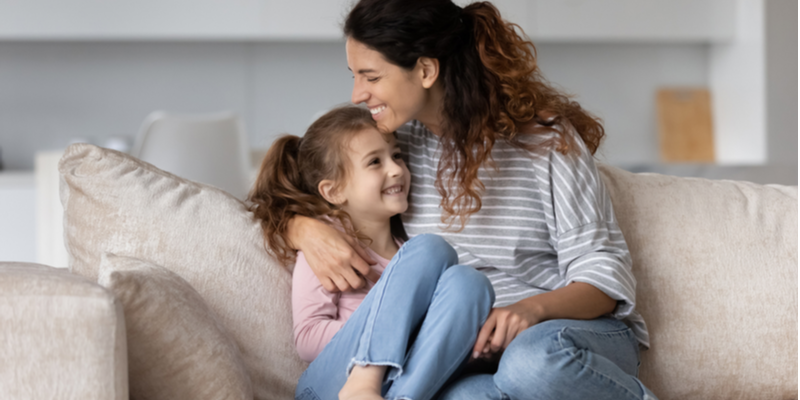 Top tips for supporting perfectionism mum and young daughter hugging on the couch