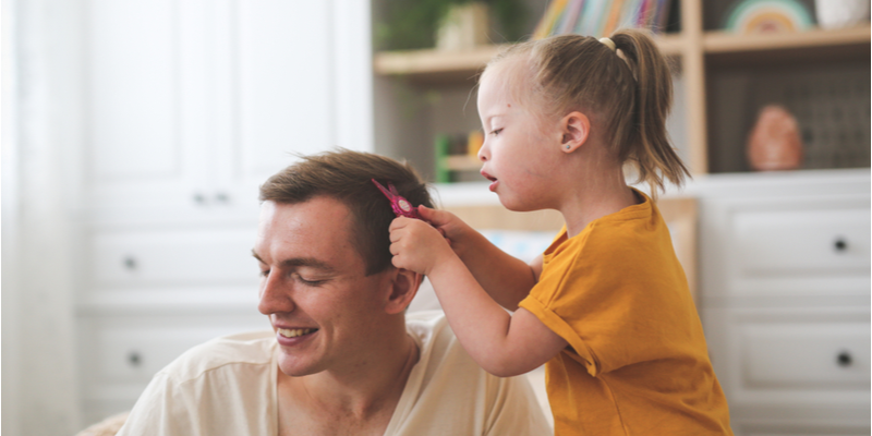 a child with Down syndrome plays with dad, daughter takes care of a young father,