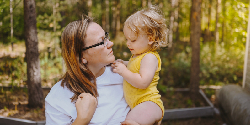 baby toddler girl blonde with curls on mothers arms