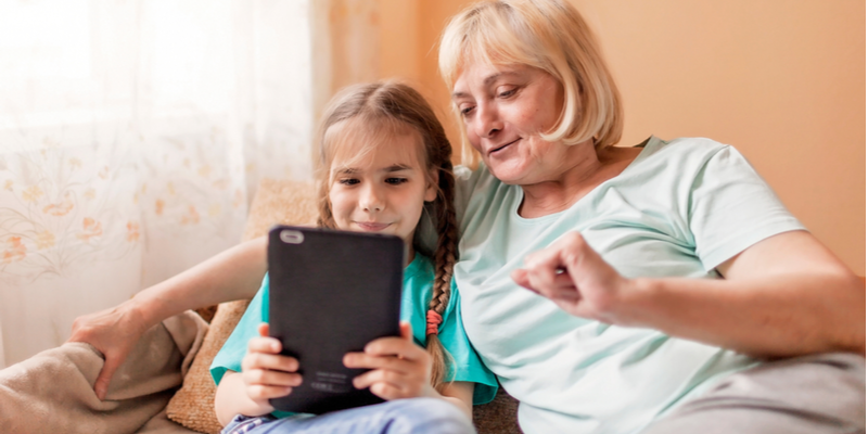 child and grandma engaged in online speech and language therapy session