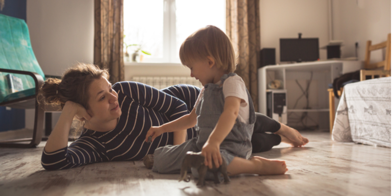 mum and young son playing on the floor with toy elephants